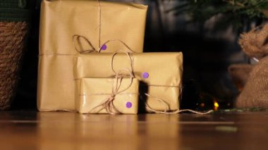 Kahverengi kağıda sarılı bir hediye ve yılbaşı ışıklarıyla iple bokeh arkaplan görüntüsü seçici odak noktası