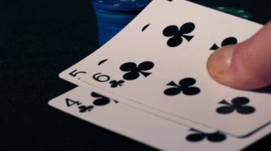 Poker oyuncusunun elinde floş var. Oyun kartlarını kapat, yakınlaştır, seçici odaklan.