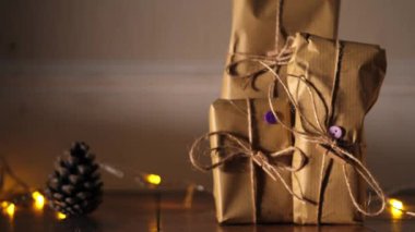 Kahverengi kağıda sarılı bir hediye ve yılbaşı ışıklarıyla iple bokeh arkaplan görüntüsü seçici odak noktası