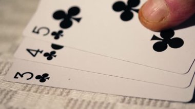 Poker oyuncusunun elinde floş var. Oyun kartlarını kapat, yakınlaştır, seçici odaklan.