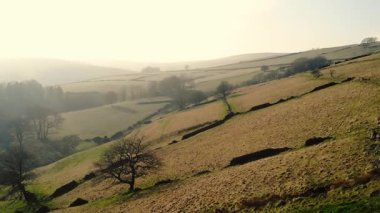 Puslu bir günde Peak District Ulusal Parkı 'ndaki kırsal tarım arazisi geniş zoom insansız hava aracı seçici odak noktası