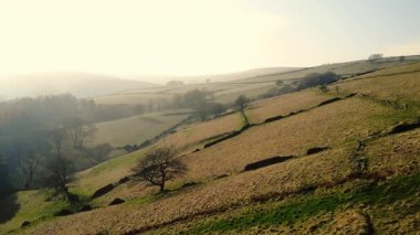 Puslu bir günde Peak District Ulusal Parkı 'ndaki kırsal tarım arazisi 4k hava aracı seçici odak noktası