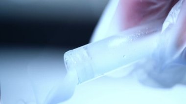 Test tüpünde sıvı deneniyor. 4k yakın çekim. Yavaş çekim seçici odak noktası.