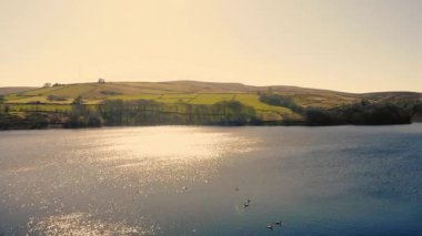 Peak District Ulusal Parkı 'ndaki göl ve tarım arazisi. Mavi gökyüzü. Geniş zoom panorama insansız hava aracı seçici odak noktası.