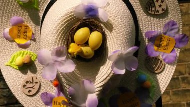 Yumurta ve çiçeklerle süslenmiş Paskalya şapkası 4k 'lık seçici odak noktasını kapat
