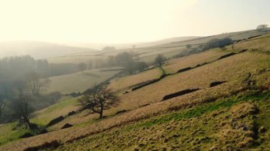 Puslu bir günde Peak District Ulusal Parkı 'ndaki kırsal tarım arazisi geniş zoom insansız hava aracı seçici odak noktası