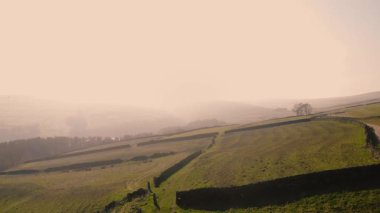 Puslu bir günde Peak District Ulusal Parkı 'ndaki kırsal tarım arazisi 4k hava aracı seçici odak noktası