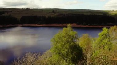 Peak District Ulusal Parkı 'ndaki göl ve tarım arazisi mavi gökyüzü manzarası geniş zoom drone hava seçici odak noktası
