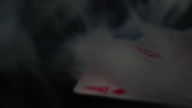 Poker el dumanlı asları tutuyor iskambil kağıtlarını kapatıyor 4k döngü yakınlaştırma görüntüsü seçici odaklanma