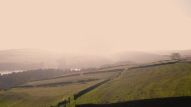 Puslu bir günde Peak District Ulusal Parkı 'ndaki kırsal tarım arazisi 4k hava aracı seçici odak noktası