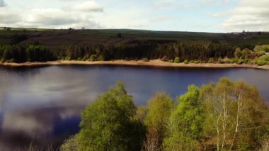 Tepe İlçesi Ulusal Parkı 'ndaki ağaçlar ve tarlalar çevresindeki göl mavi gökyüzü geniş 4k hava aracı seçici odak noktası