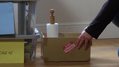 Kırılgan kutuyu yeni ev ortamına taşıyan kadın seçici odak noktası