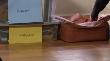 Yeni evdeki bavul ve kutuları boşaltan kadın 4K seçici odak noktasını vurdu.