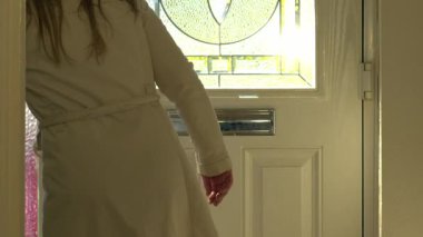 Kadın yaz günü evden çıkıyor. Orta karar seçici odak noktası. 