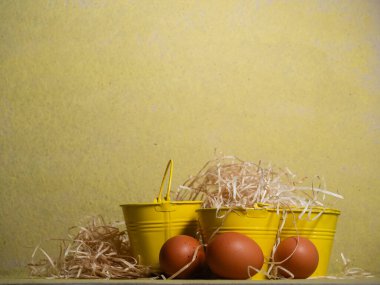 Sarı zemin üzerinde serbest yumurta ve saman yakın çekim seçici odak