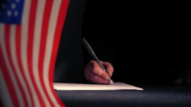 Amerikan bayrağıyla el imzalı bir ticaret anlaşması. Orta boy seçici odaklanma.