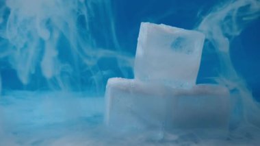Mavi zemin üzerinde kuru buz olan buz küpleri 4k 'lık seçici odak noktasını kapat