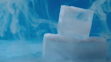 Mavi zemin üzerinde kuru buz soğutmalı buz küpleri yakın çekim odaklı seçici odaklanma