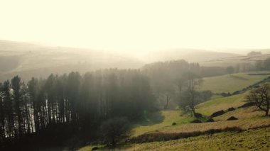 Puslu bir günde Peak District Ulusal Parkı 'ndaki kırsal tarım arazisi geniş zoom insansız hava aracı seçici odak noktası