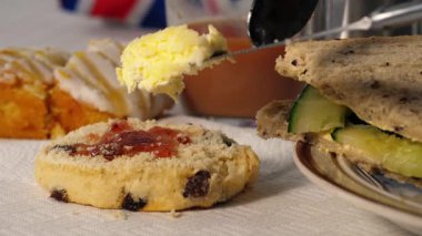 Geleneksel İngiliz çayı, çörek pıhtılaşmış kremalı ve salatalıklı sandviçler. Yakın çekim odaklı.