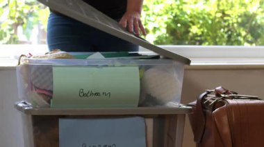 Plastik kutuları olan kadın yeni ev ortamına taşınıyor. 4k seçici odak noktası.