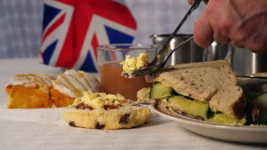Çörek kremalı ve salatalıklı geleneksel İngiliz çayı 4K 'lık seçici odak noktasını kapat.