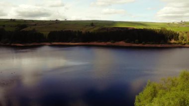 Tepe İlçesi Ulusal Parkı 'ndaki ağaçlar ve tarlalar çevresindeki göl mavi gökyüzü geniş 4k hava aracı seçici odak noktası