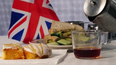 Geleneksel İngiliz çayı, pastalar ve salatalıklı sandviçler seçici odak noktası.