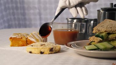 Geleneksel İngiliz çayı reçelli çörek ve salatalıklı sandviç seçici odaklı orta boy.