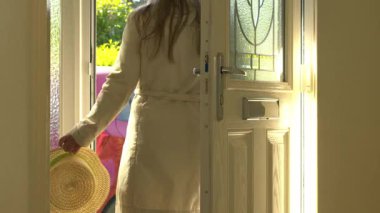 Bir kadın yaz günü evden çıkar. 4K seçici bir odak noktası. 