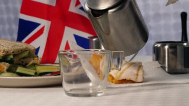 Geleneksel İngiliz çayı, pastalar ve salatalıklı sandviçler yakın çekim odaklı.