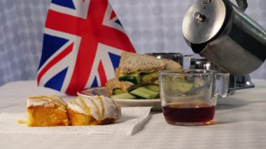 Traditional English tea with cakes and cucumber sandwiches medium 4k shot selective focus