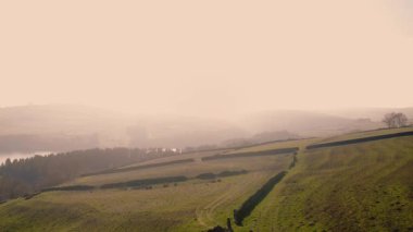 Puslu bir günde Peak District Ulusal Parkı 'ndaki kırsal tarım arazisi 4k hava aracı seçici odak noktası