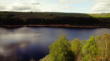 Tepe İlçesi Ulusal Parkı 'ndaki ağaçlar ve tarlalar çevresindeki göl mavi gökyüzü geniş 4k hava aracı seçici odak noktası