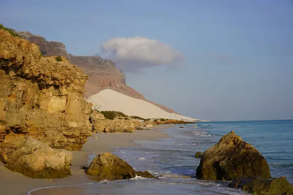 Güzel tropikal ada gün doğumu manzarası: Mavi deniz, altın uçurumlar ve beyaz kumlu sahil - Socotra Adası, Yemen