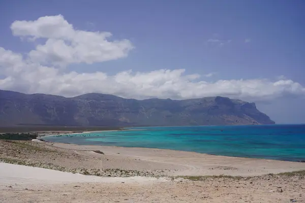 Güzel tropikal ıssız ada gündoğumu manzarası: Mavi deniz, altın uçurumlar ve beyaz kumlu sahil - Socotra Adası, Yemen