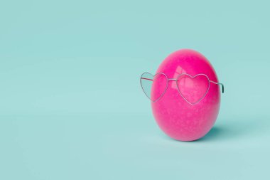 3D rendering of creative hearts shaped eyeglasses in bright painted pink Easter egg against blue background clipart