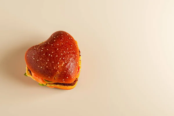 Wysoki Kąt Apetyczny Hamburger Kształcie Serca Świeżymi Zielonymi Plastrami Warzyw — Zdjęcie stockowe
