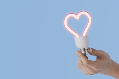 Ellerinde kalp şeklinde bir ampul var. Sevgililer Günü 'nde aşk fikrini temsil ediyor. 3d oluşturma