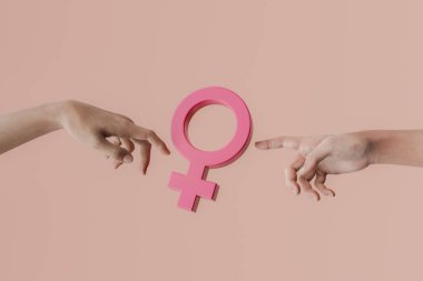 İki el pembe bir kadın cinsiyet sembolünü işaret ederek kadın hakları ve cinsiyet eşitliğini destekliyor. 3d oluşturma