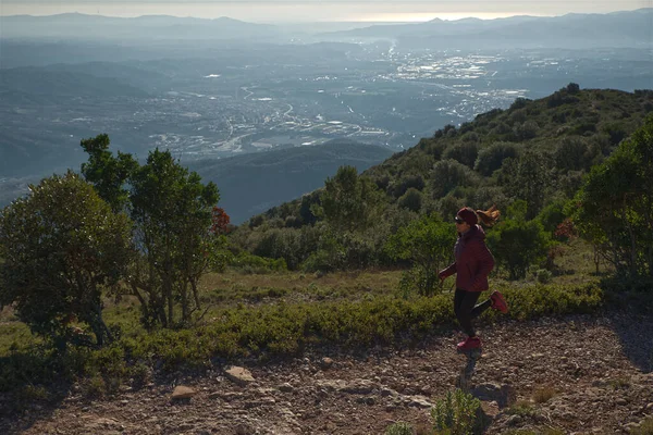 Woman runs through the mountains of Montserrat in Catalonia, Spain.