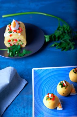 Mavi arka planda top şeklinde sunulan Causa adı verilen tipik Peru yemekleri..