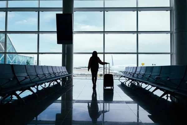 Vrouw Met Koffer Hand Kijkt Uit Het Raam Van Luchthaven — Stockfoto