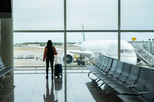 Vrouw Met Koffer Hand Kijkt Uit Het Raam Van Luchthaven — Stockfoto