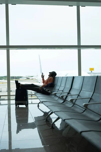 Mulher Verifica Seu Telefone Celular Enquanto Espera Seu Voo Aeroporto — Fotografia de Stock