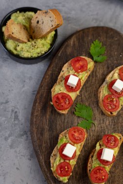 Kızarmış ekmek, avokado, vişneli domates ve peynirli tuzlu mezeler..