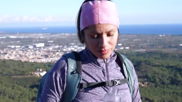 女はガラス瓶から水を飲んで 山の頂上に到達した後 — ストック動画