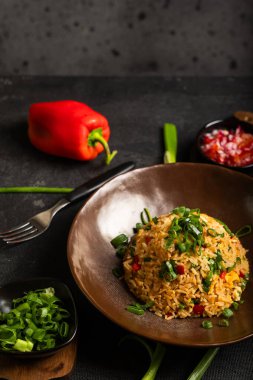 Çok renkli Peru yemekleri koyu bir arka planda bazı malzemelerle sunuluyor..