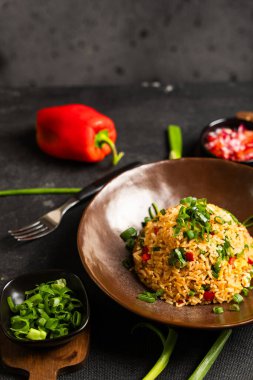 Çok renkli Peru yemekleri koyu bir arka planda bazı malzemelerle sunuluyor..
