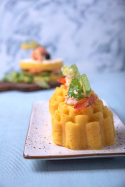 Causa rellena adlı geleneksel Peru yemeği açık mavi arka planda beyaz bir tepside servis edilir..